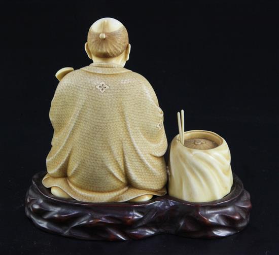 A Japanese ivory okimono of a kneeling musician, early 20th century, height 9.3cm, wood stand, damage to shamisen